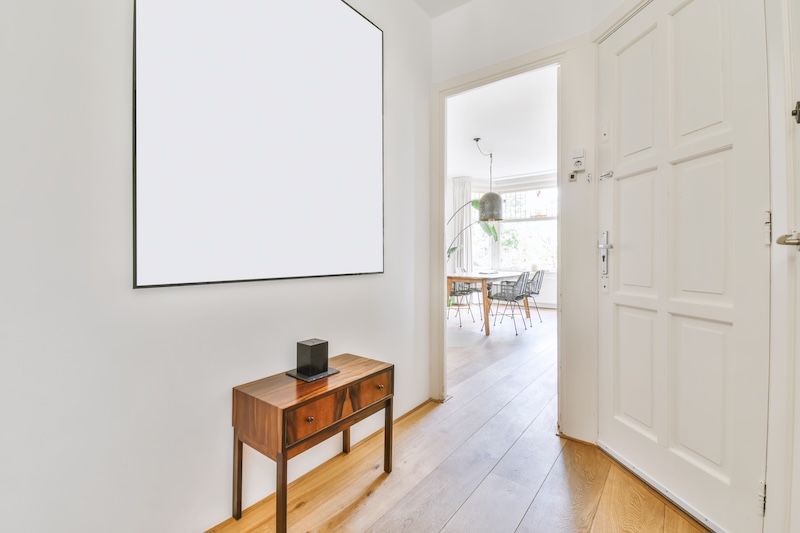 biały przedpokój z lustrem i szafką 