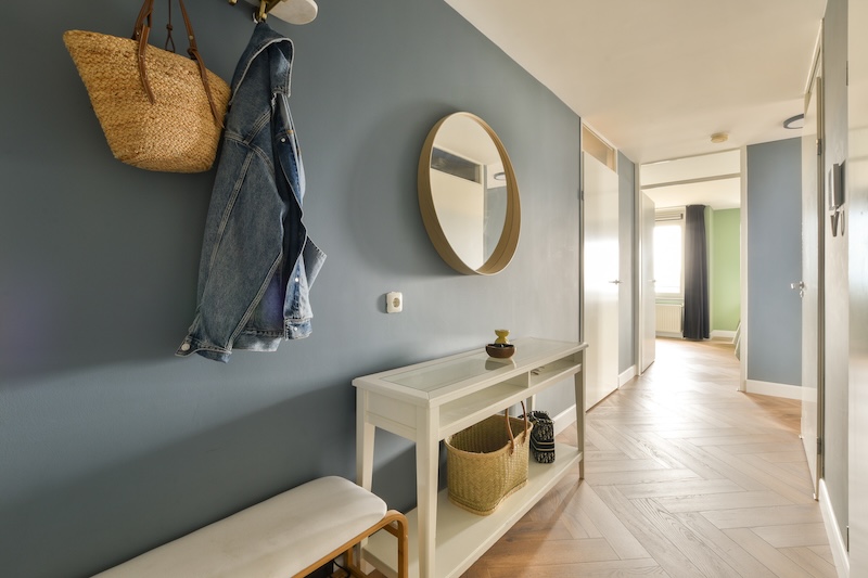 przedpokój z niebieskimi ścianami i lustrem 