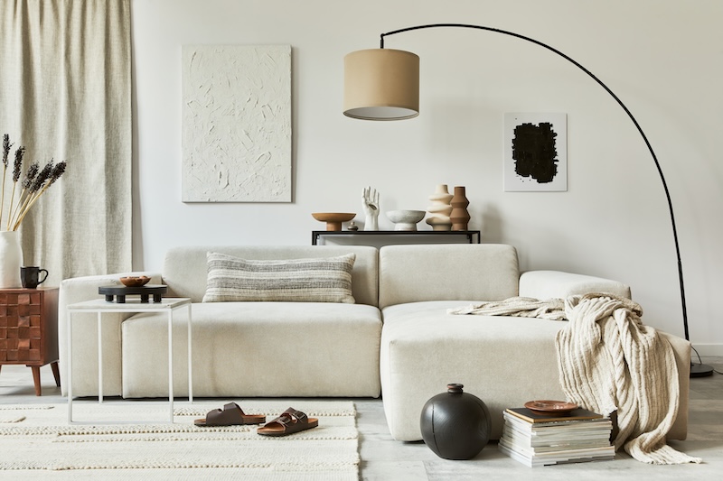 salon w neutralnych odcieniach beżu z minimalistycznymi meblami salon w odcieniach beżu z szeroką kanapą
