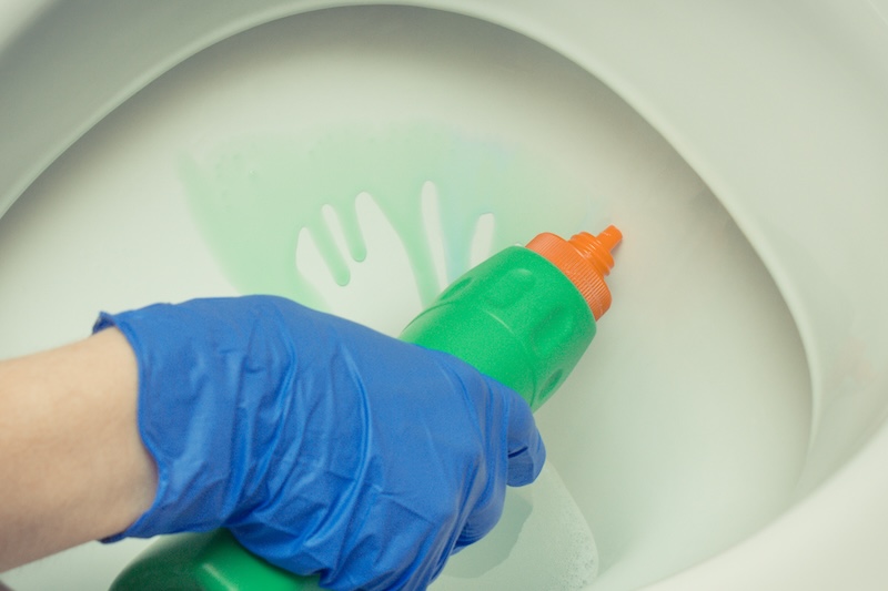 polewanie wnętrza toalety detergentem wlewanie chemikaliów do muszli klozetowej